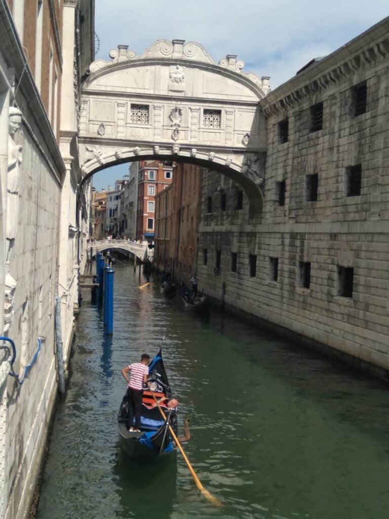 The bridge of sighs in Venice, Italy  with a few gondolas in the water. Some wonder about affiliate bridge page mistakes to avoid.
