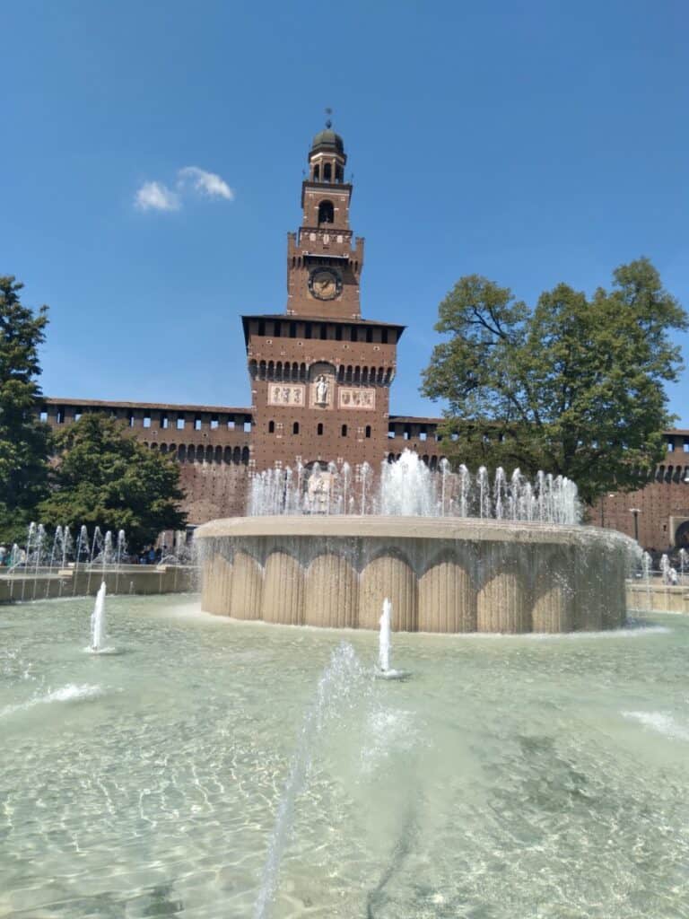 A unique fountain with a castle behind it, taken in Rome, Italy.