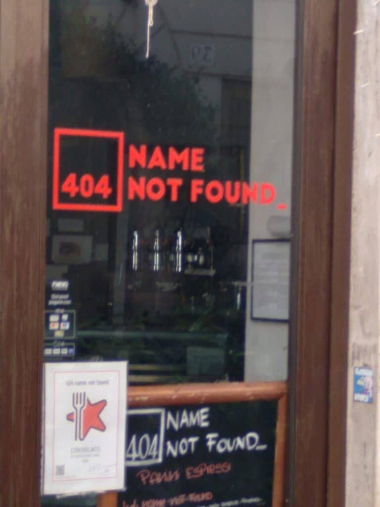 A photo of a shop sign saying "404 name not found" some wonder Can you use systeme io without a custom domain